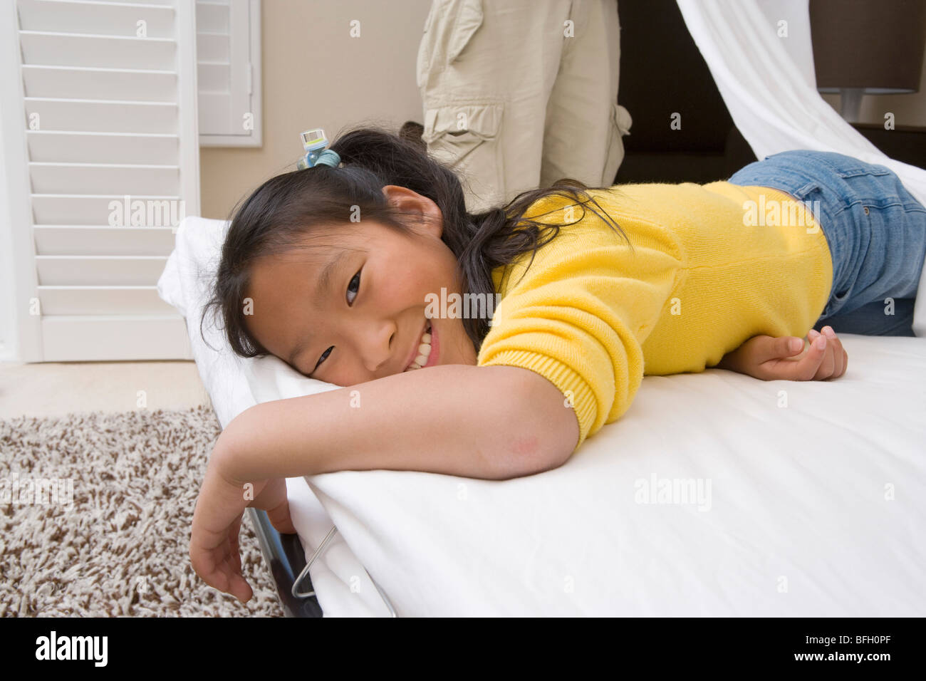 Girl lying down on bed and smiling Banque D'Images