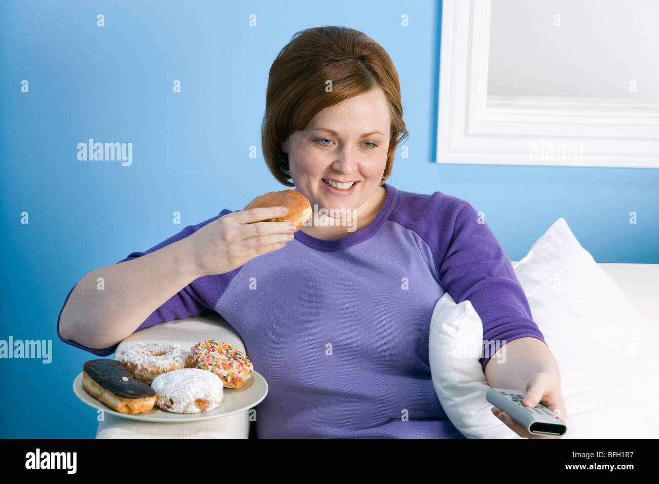 L'excès de femme à regarder la télévision, manger Banque D'Images