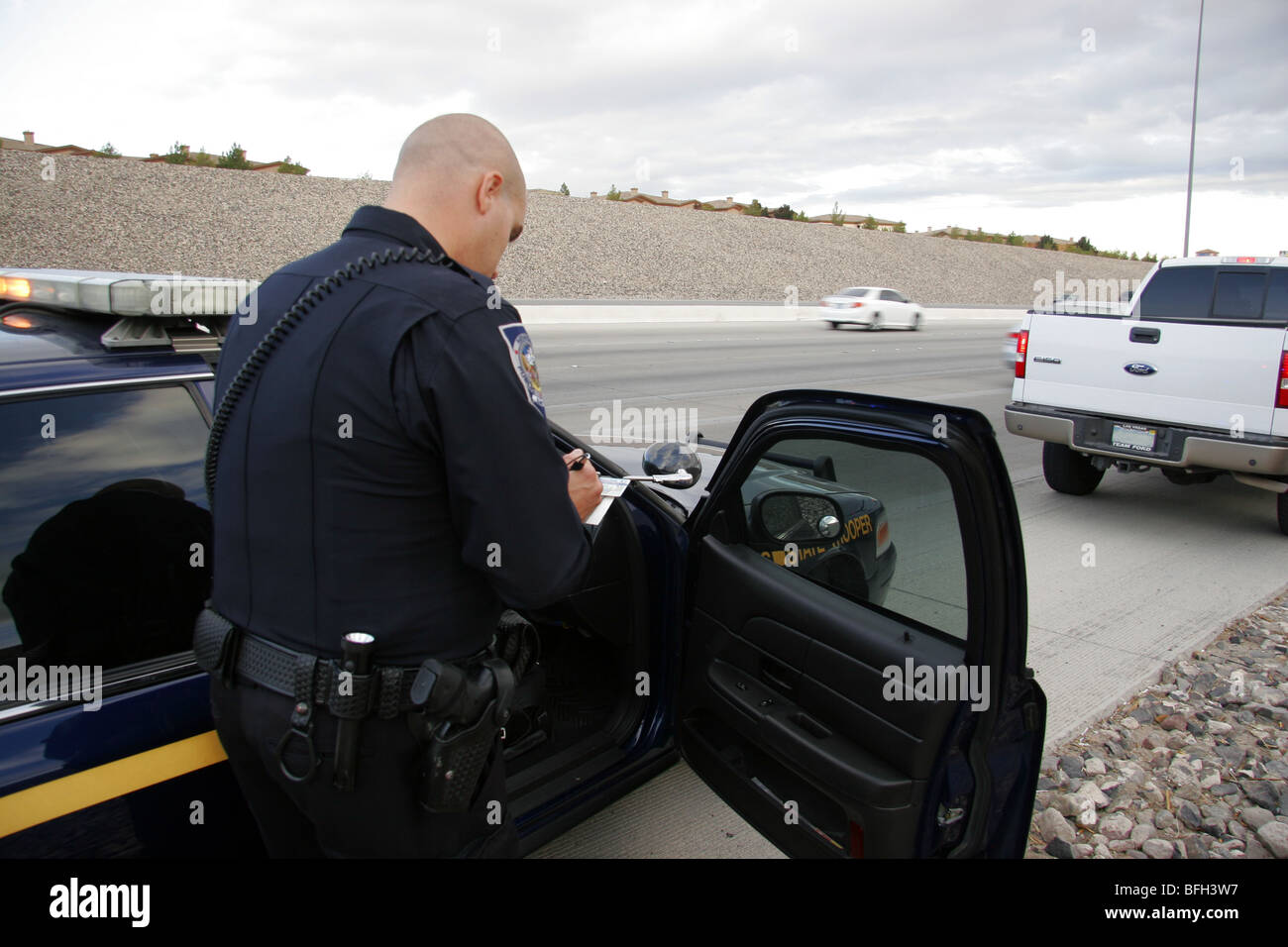 Nevada Highway Patrol State Trooper écrit un billet après l'arrêt d'un véhicule pour une infraction routière. Banque D'Images