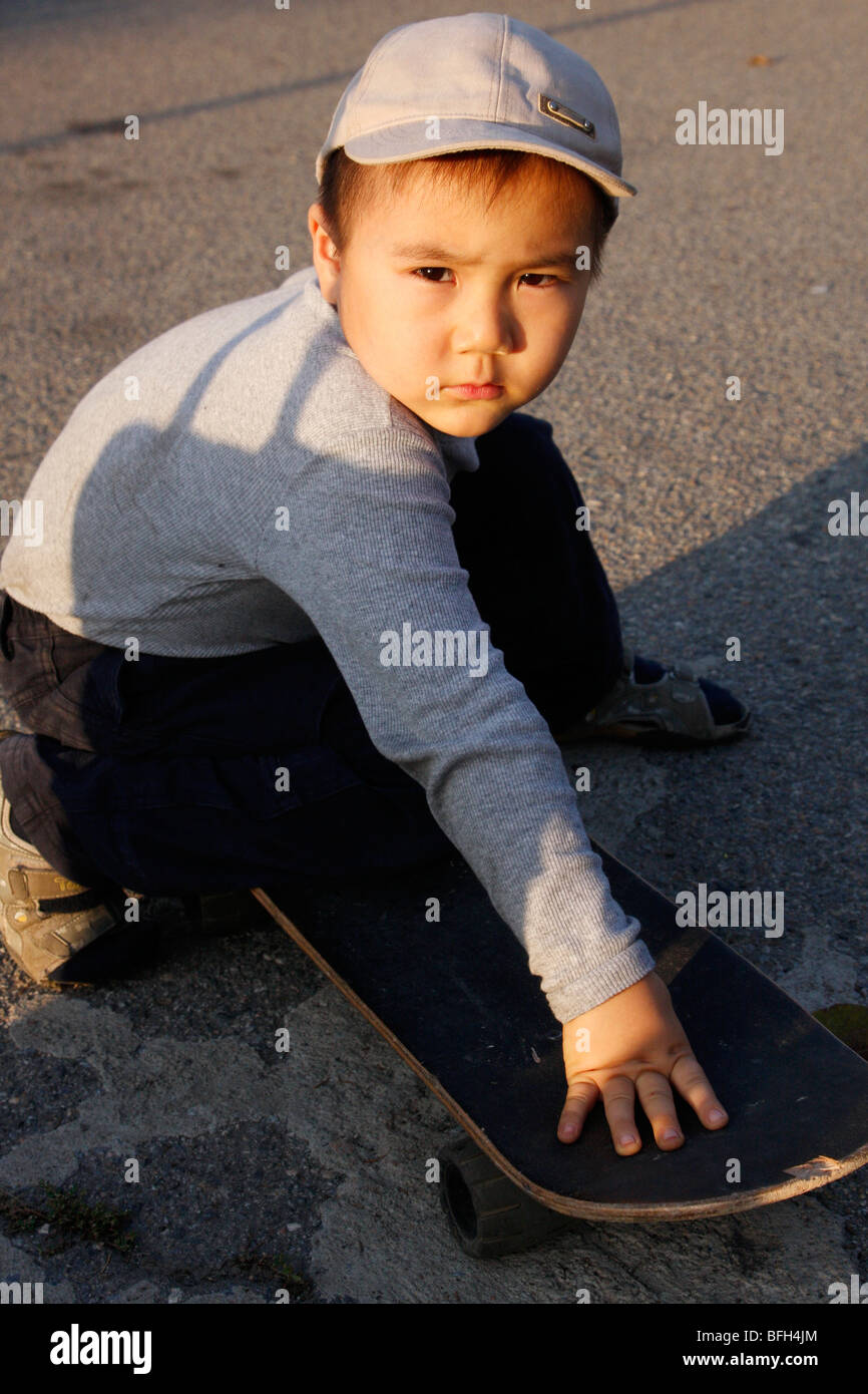 Garçon Rayimbek kazakh sur une planche à roulettes sur une rue à Almaty, Kazakhstan Banque D'Images