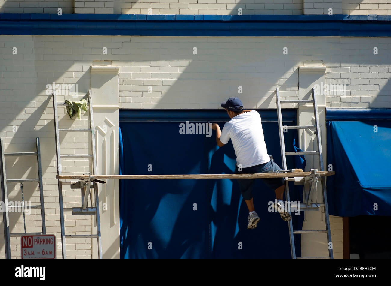 Un entrepreneur ne l'élaboration des mises et la peinture dans un quartier d'affaires de Orange County. Banque D'Images