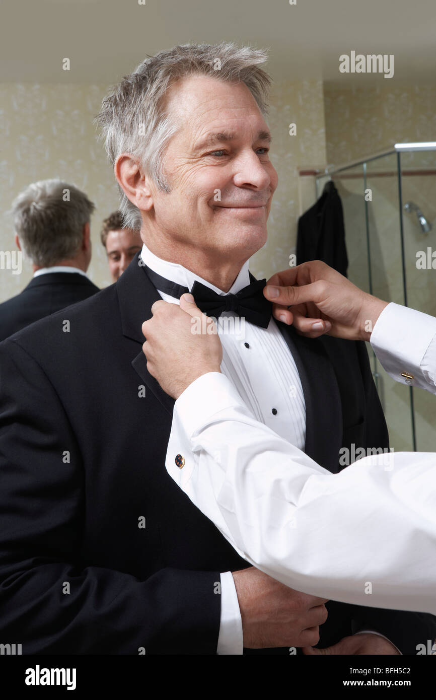 Jeune homme attachant middle-aged man's Bow Tie Banque D'Images