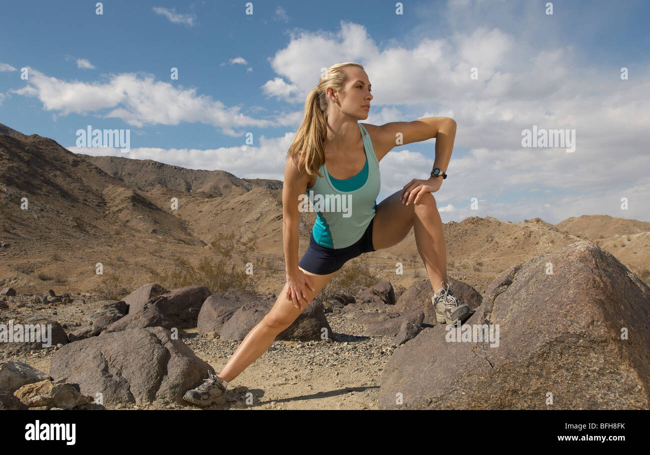 Female jogger stretching en montagne Banque D'Images