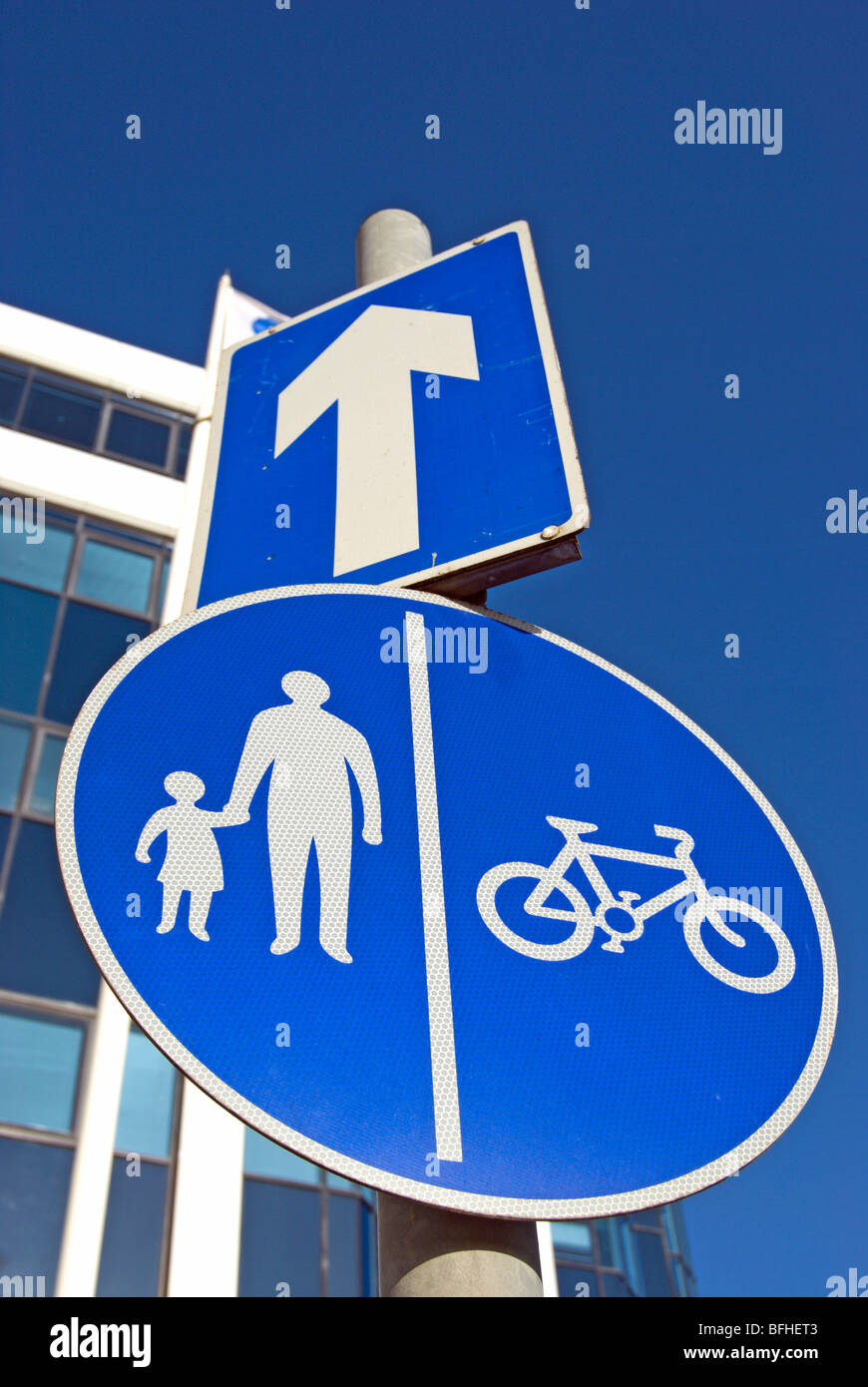 La signalisation routière indiquant une rue à sens unique, d'une flèche blanche, et des couloirs séparés pour les cyclistes et piétons Banque D'Images