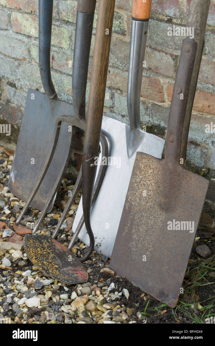 Les pelles de jardin et d'outils s'appuyant sur mur de brique Banque D'Images