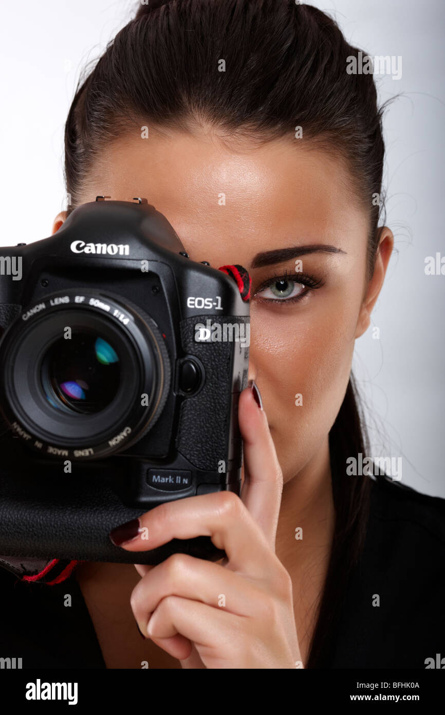 Jeune brunette de 20 ans est titulaire d'Canon 1d portant un gilet photographique canon Banque D'Images