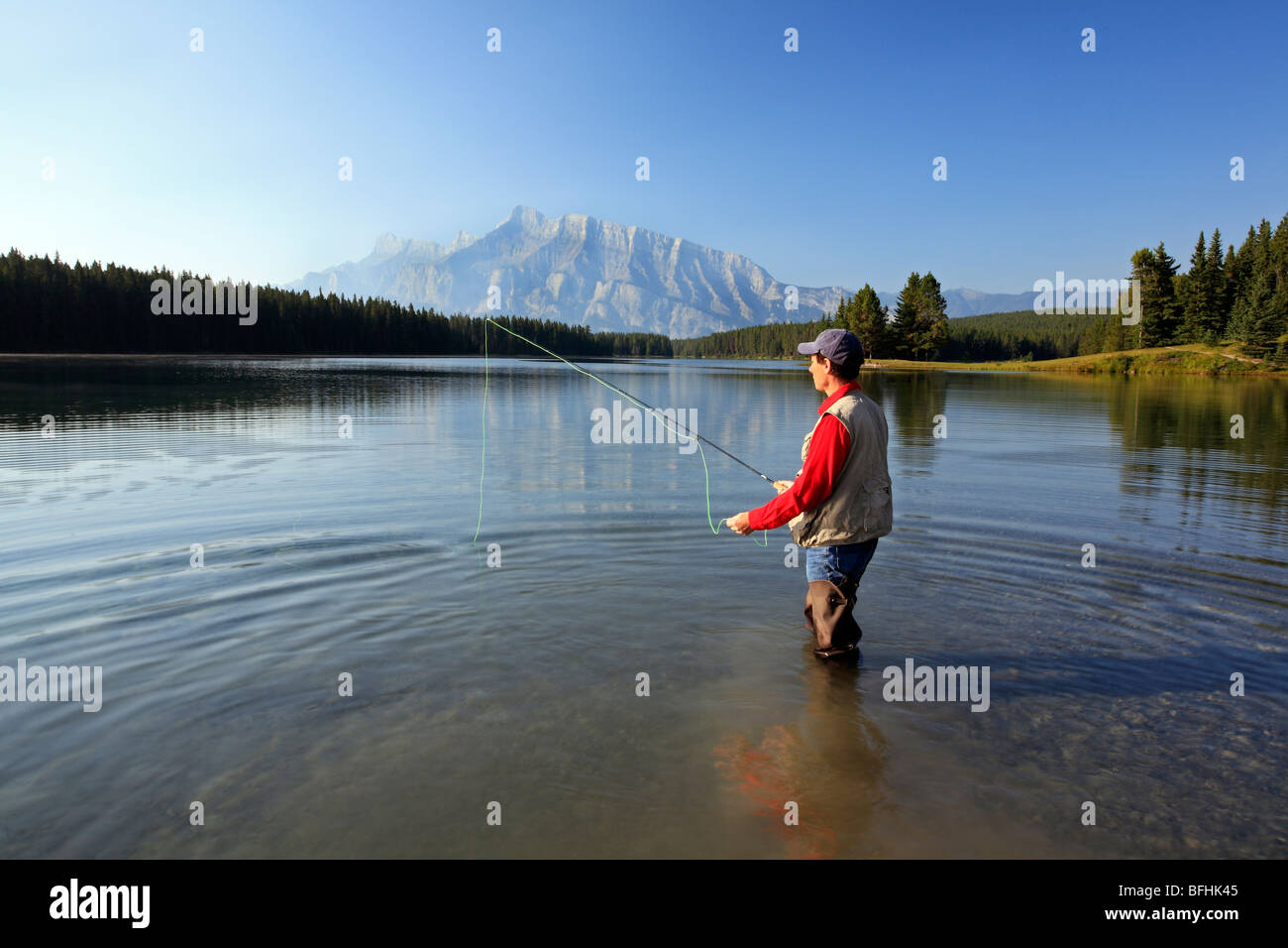 L'âge moyen des hommes de mouche au lac de montagne. Le lac Two Jack, Rundle Mountain background, Banff National Park, Alberta, Canada. Banque D'Images