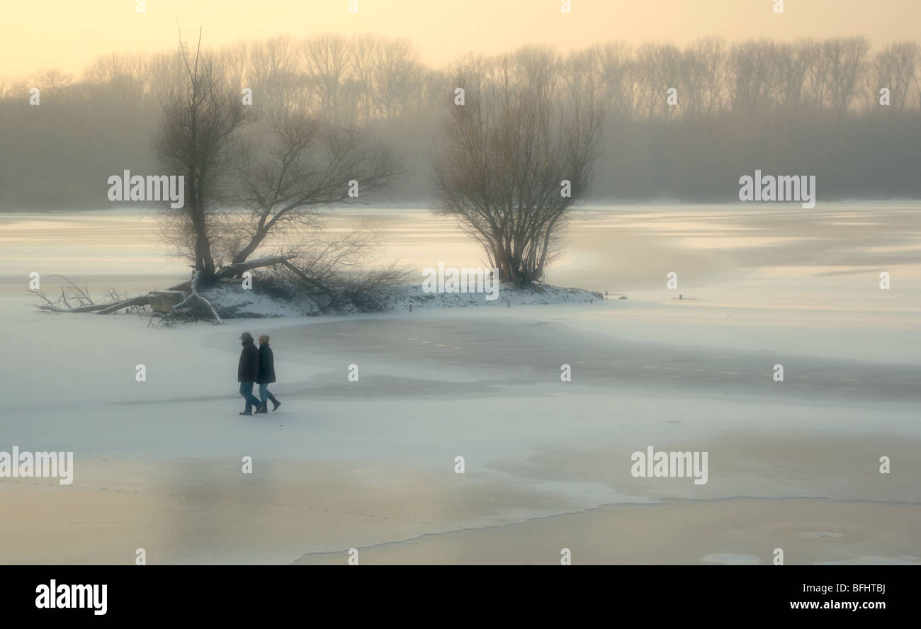 Couple en train de marcher sur une plaque de glace dans un paysage d'hiver Banque D'Images