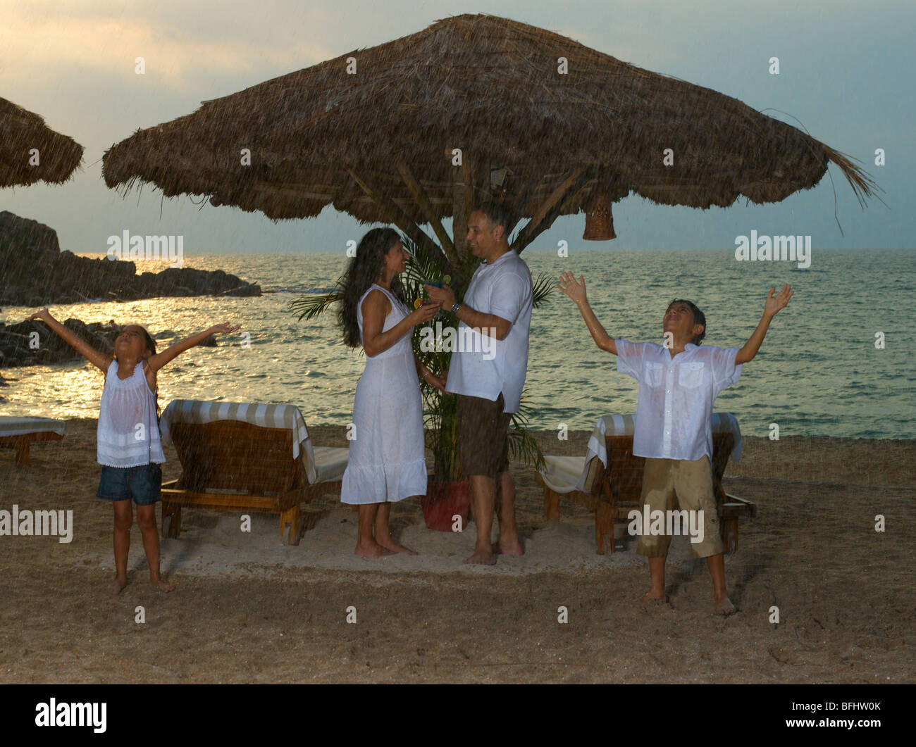 Leurs vacances en famille dans une station sous la pluie de mousson à la plage Banque D'Images