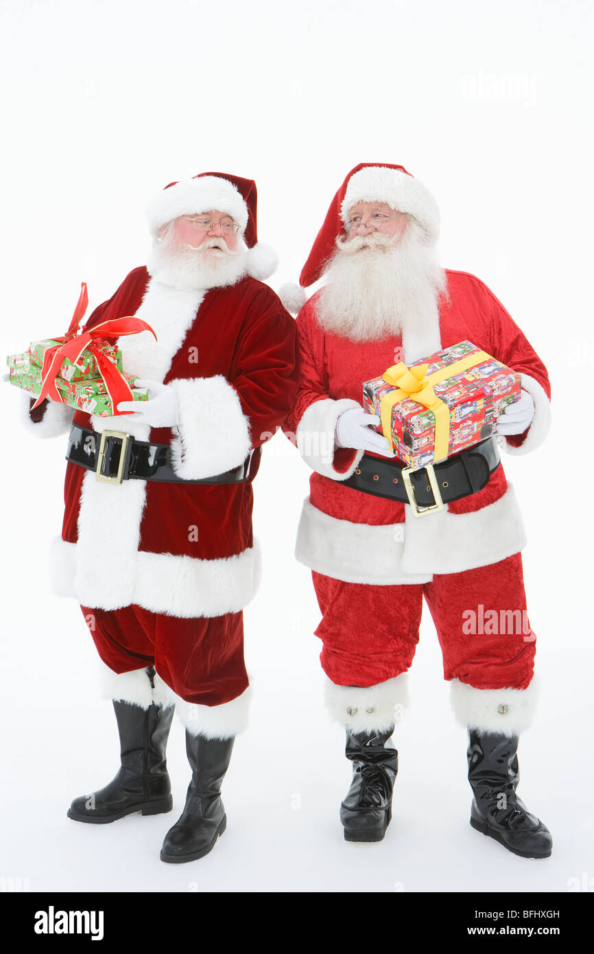 Deux hommes habillés en Père Noël holding gifts Banque D'Images