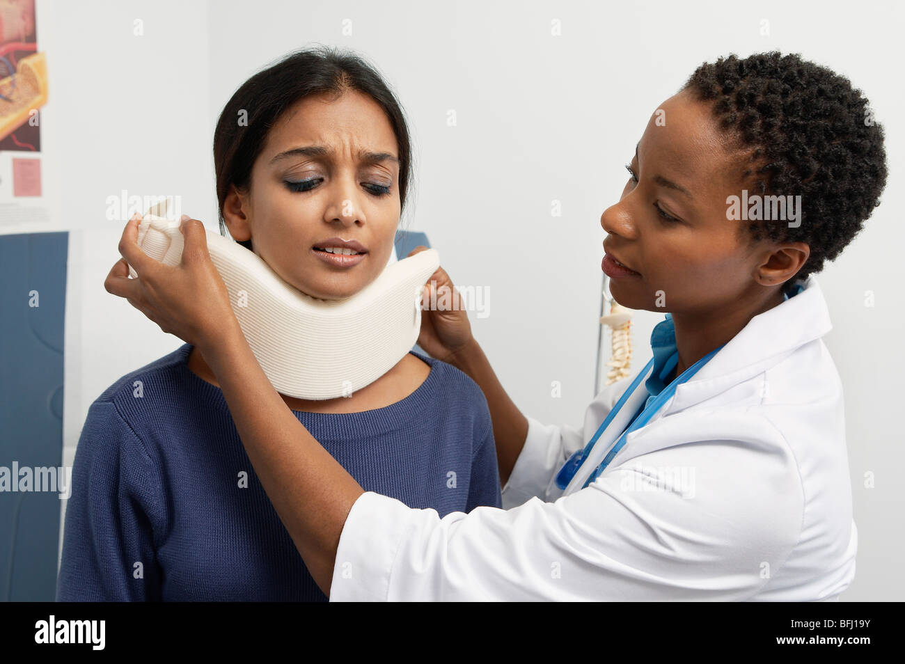 Femme médecin puting renfort au cou du patient Banque D'Images