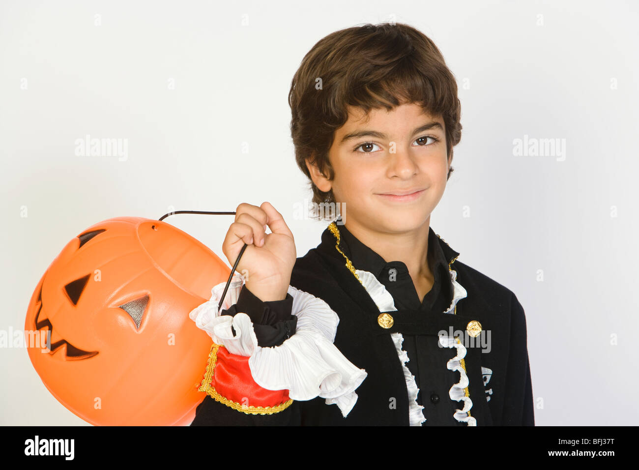 Portrait of boy (7-9) wearing costume Halloween, avec jack-o-lantern Banque D'Images