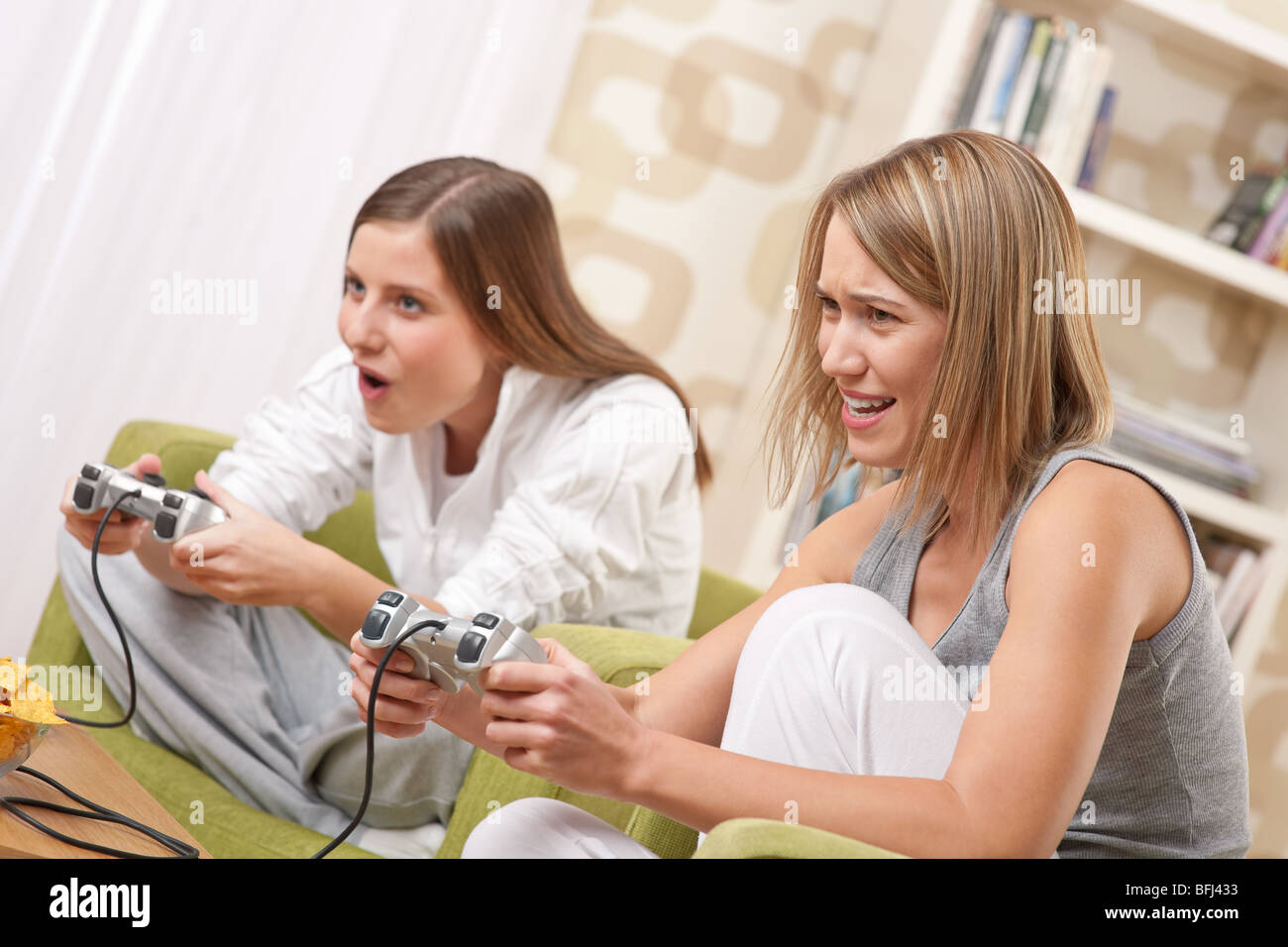 - Deux étudiants happy female teenager playing TV Game et s'amuser Banque D'Images