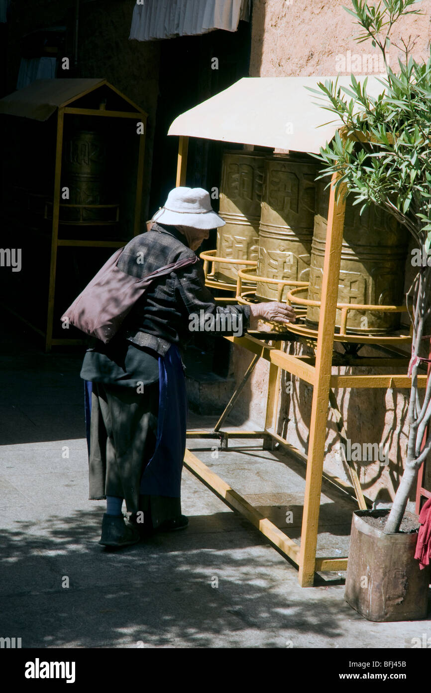 Pèlerin tibétain de femme tournant les roues de prière à l'ani sangkhung antiq lhassa Banque D'Images