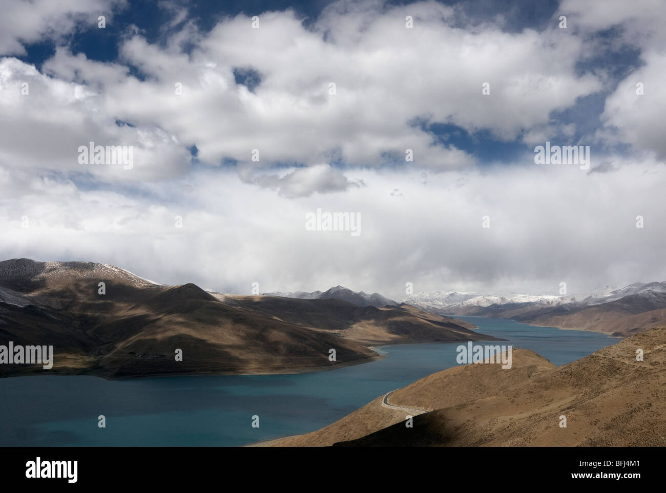 Vue sur le lac Yamdrok Tso ou turquoise avec montagnes ciel nuages et la neige pris depuis le sommet de l'kamba la pass Banque D'Images