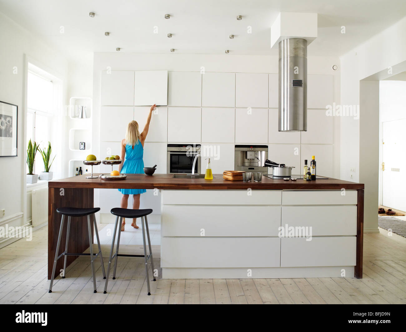 Une femme dans une cuisine blanche, la Suède. Banque D'Images