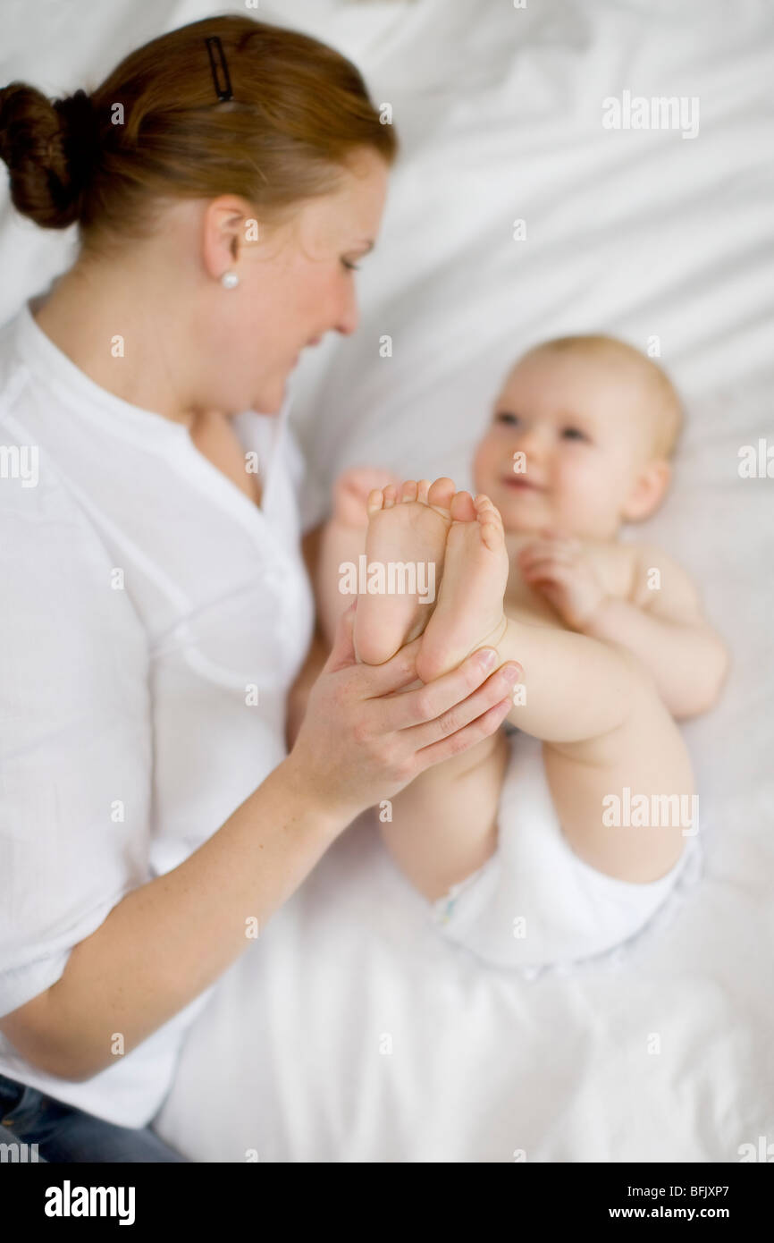 Mère au lit tenant son bébé, la Suède. Banque D'Images