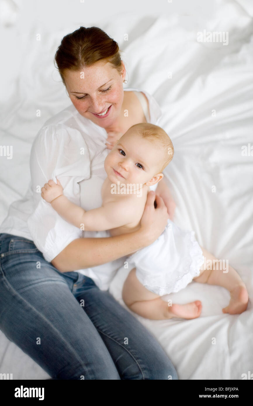 Mère au lit tenant son bébé, la Suède. Banque D'Images