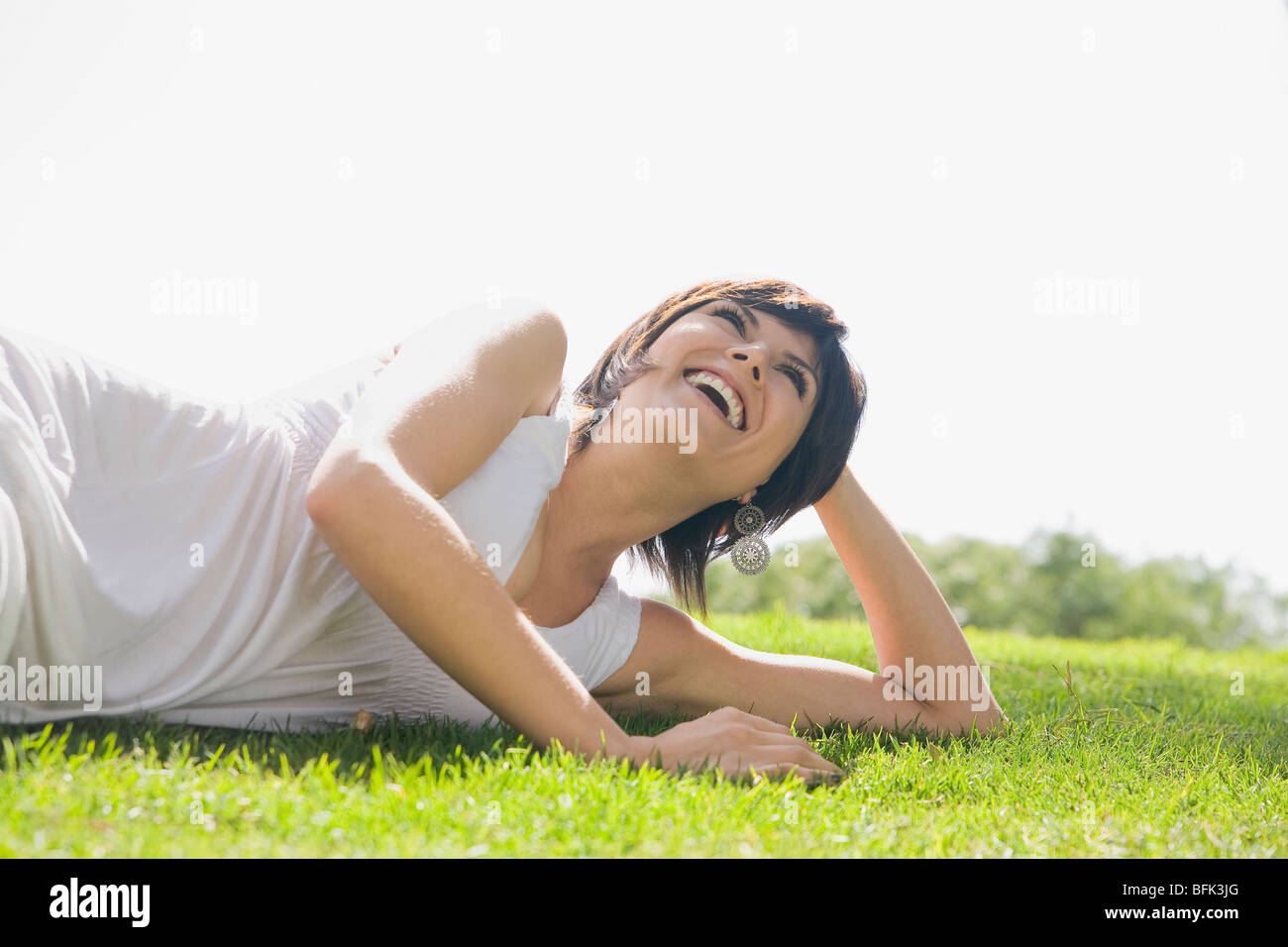 Hispanic woman laying in grass Banque D'Images