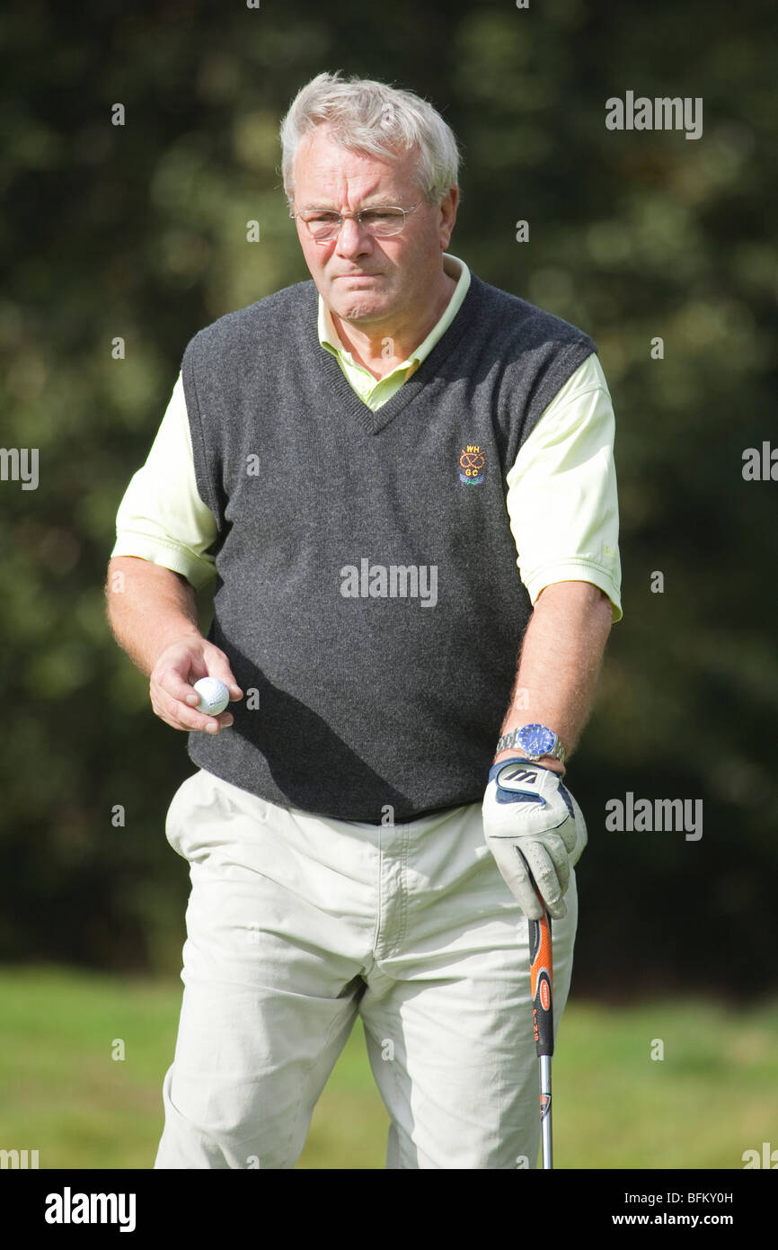 Un homme de race blanche portant des lunettes en jouant au golf club et la  tenue d'un blanc d'une balle de golf Photo Stock - Alamy
