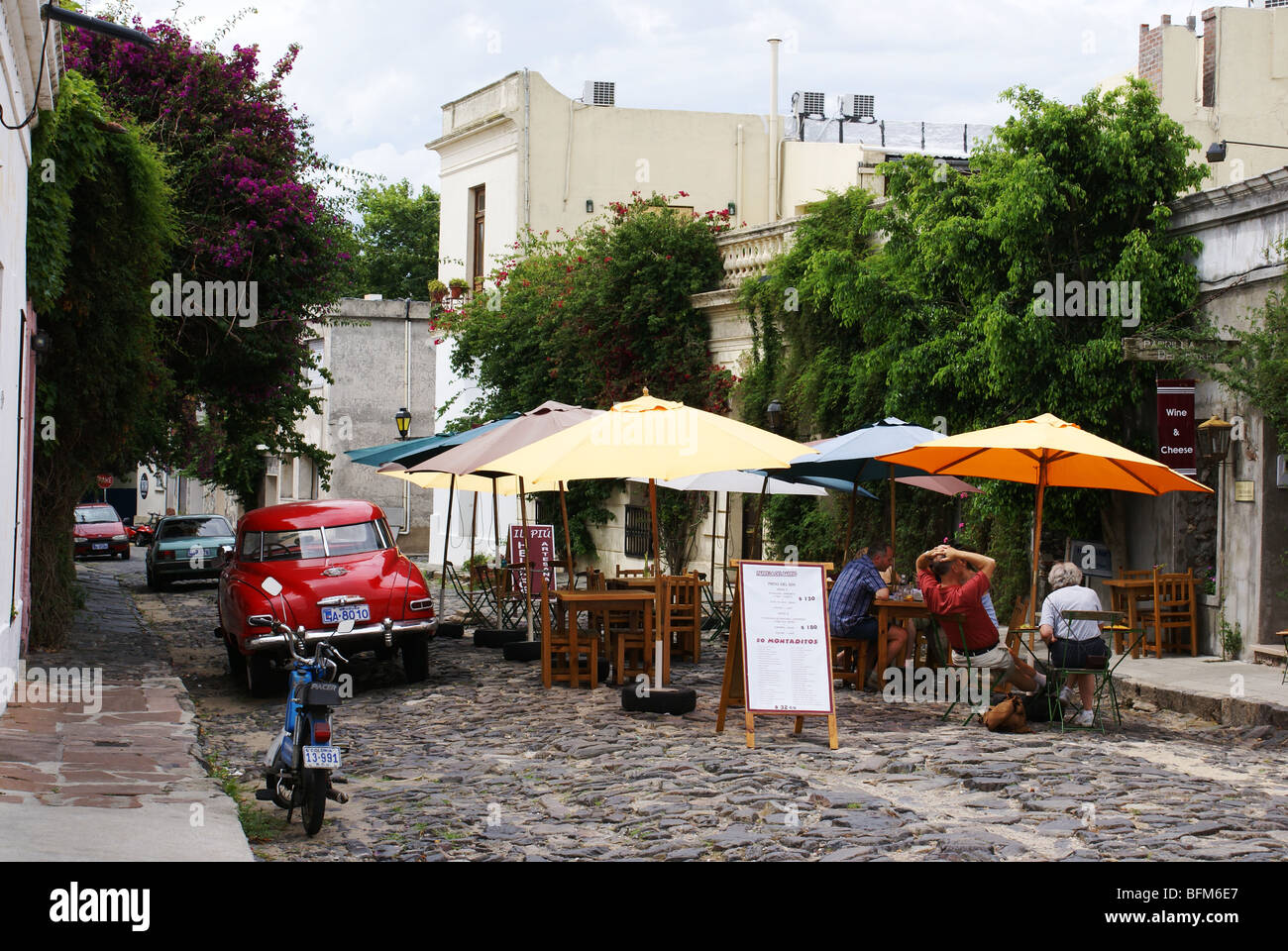 Les touristes en terrasse de café dans la vieille rue pavée de Colonia del Sacramento, Uruguay. Banque D'Images