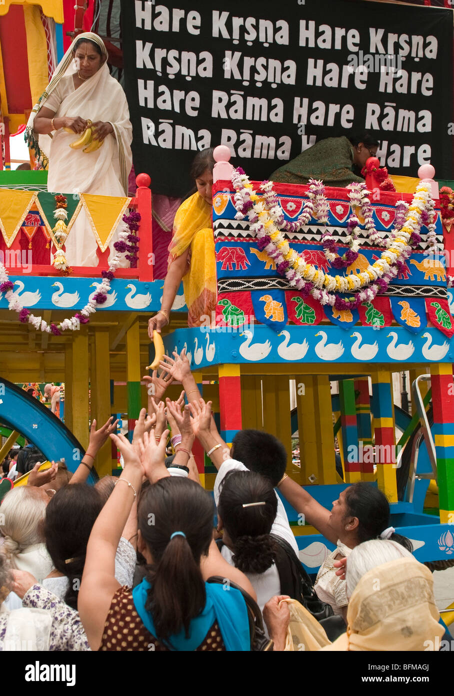 Les fidèles de recevoir des fruits d'un des trois chars au cours de la fête hindoue de Ratha Yatra London UK Banque D'Images