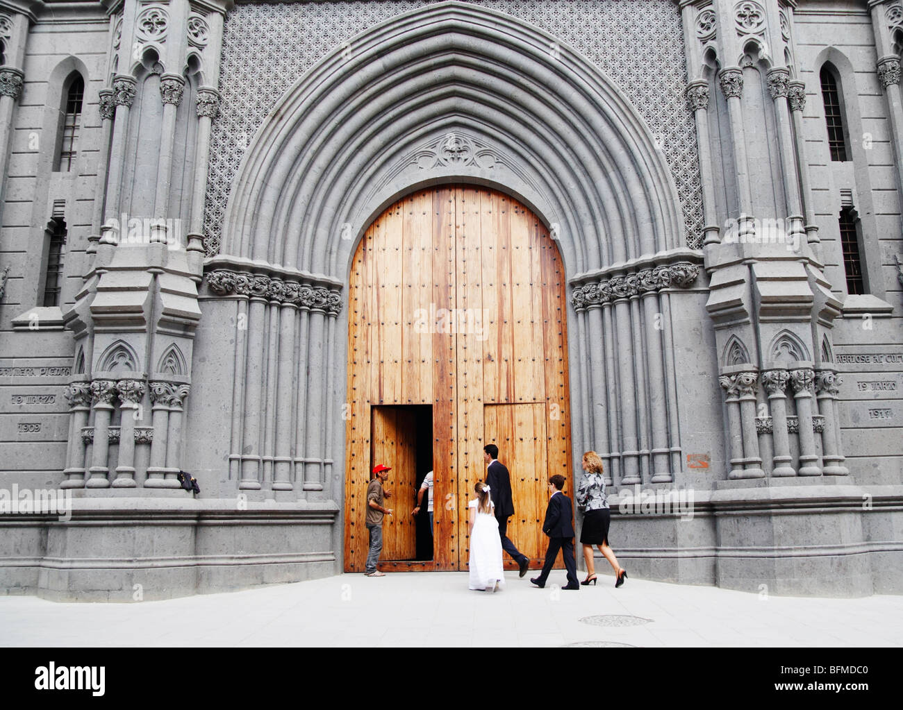 Jeune fille espagnole en robe de première communion avec l'église dans la famille. Banque D'Images