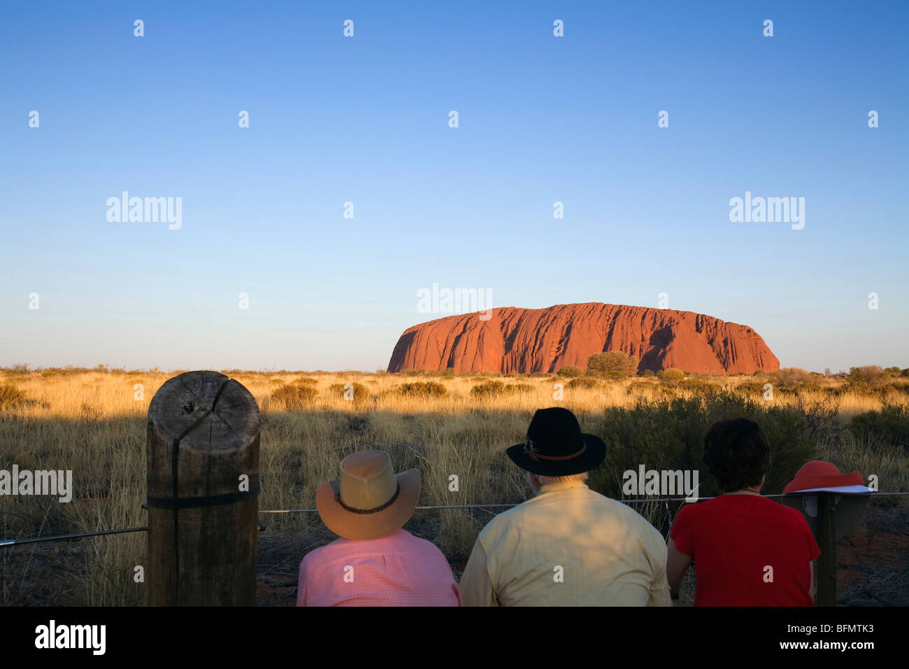 L'Australie, Territoire du Nord, le Parc National d'Uluru-Kata Tjuta. Les touristes regarder le coucher du soleil sur Uluru (Ayers Rock). (PR) Banque D'Images