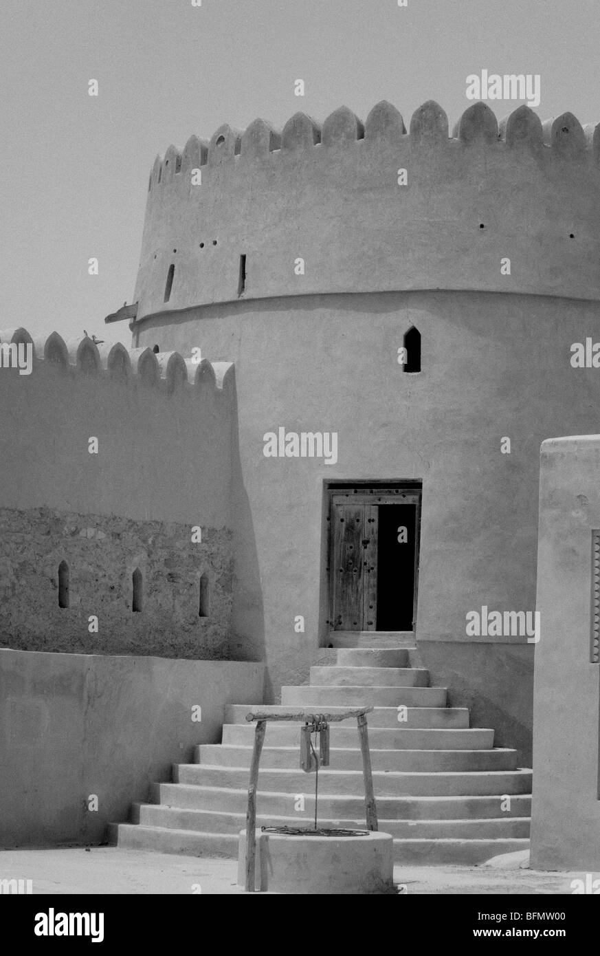 Oman, Batinah Coast. Un puits se trouve en face d'une des tours de guet de Barka Fort, un site important sur la côte de Batinah. Banque D'Images