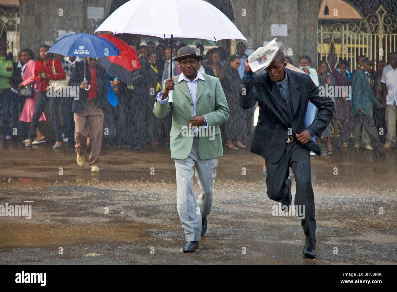 Kenya, Nairobi. Les banlieusards brave la pluie à Nairobi Railway Station. Banque D'Images