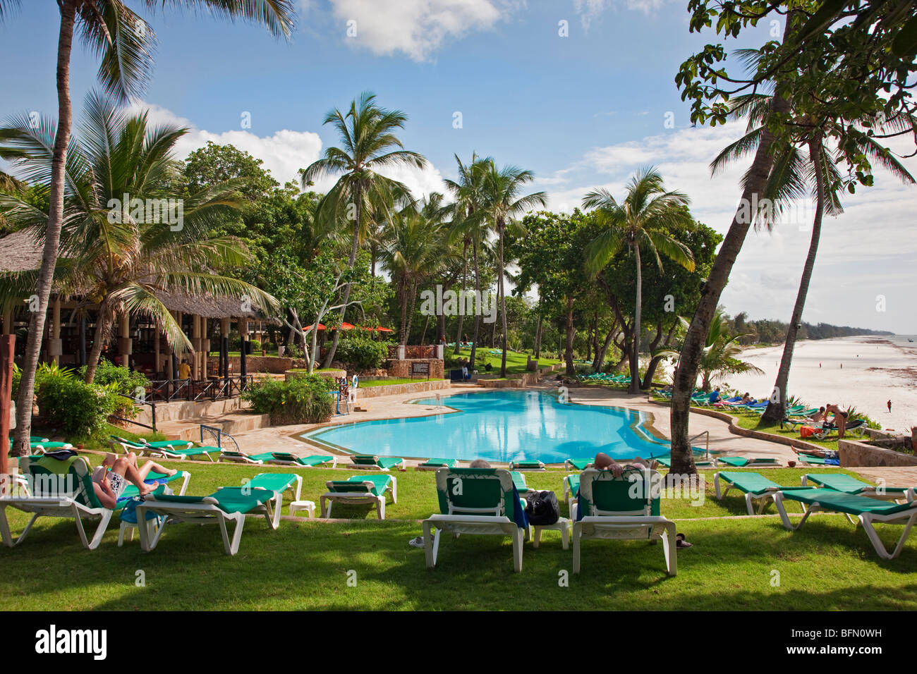 Kenya, Mombasa. La piscine de Baobab Resort avec la plage de sable blanc de Diani à l'arrière-plan. Banque D'Images