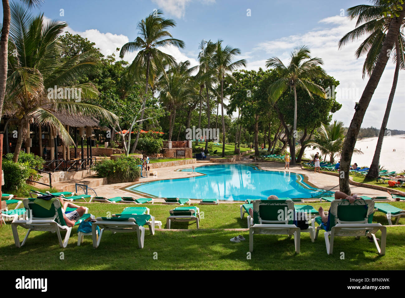 Kenya, Mombasa. La piscine de Baobab Resort avec la plage de sable blanc de Diani à l'arrière-plan. Banque D'Images