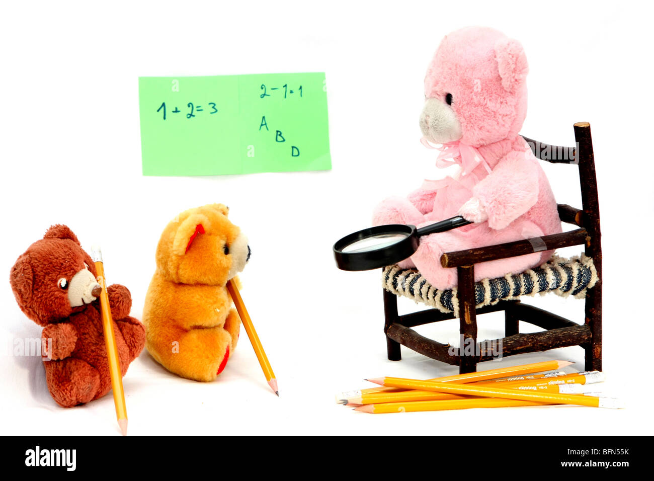 Ours en peluche dans un environnement de salle de classe enseigne deux petites poupées oursons sur fond blanc Banque D'Images
