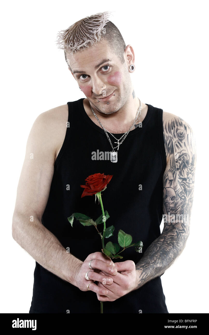 Studio shot blushing romantique coeur timide avec tatouage et piercing tenant une rose Banque D'Images