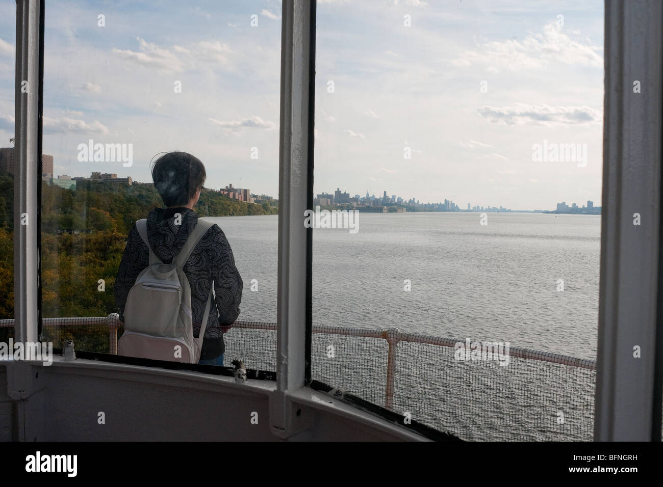 Un visiteur prend de l'avis de l'Hudson River et le New Jersey New York skylines du sommet du petit phare rouge Banque D'Images