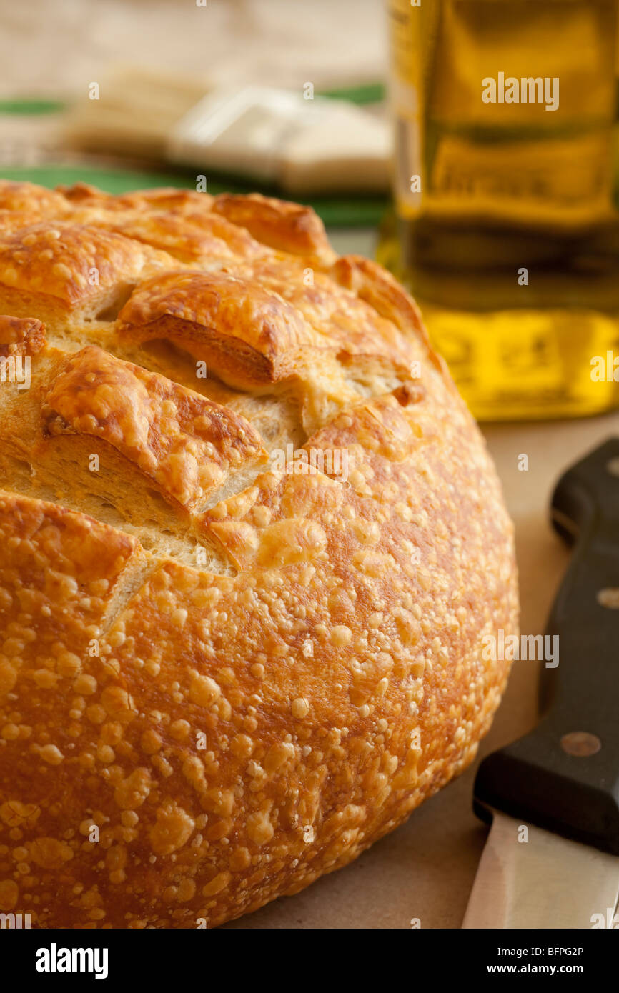 Ronde du four à pain d'une livre de pain au levain artisan conçu avec de l'huile d'olive et 1 en arrière-plan. Banque D'Images