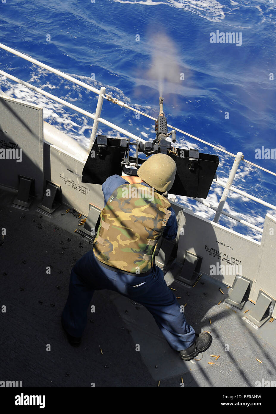 Gunners Mate tirant une mitrailleuse de calibre .50 à bord du croiseur lance-missiles USS Vella Gulf. Banque D'Images