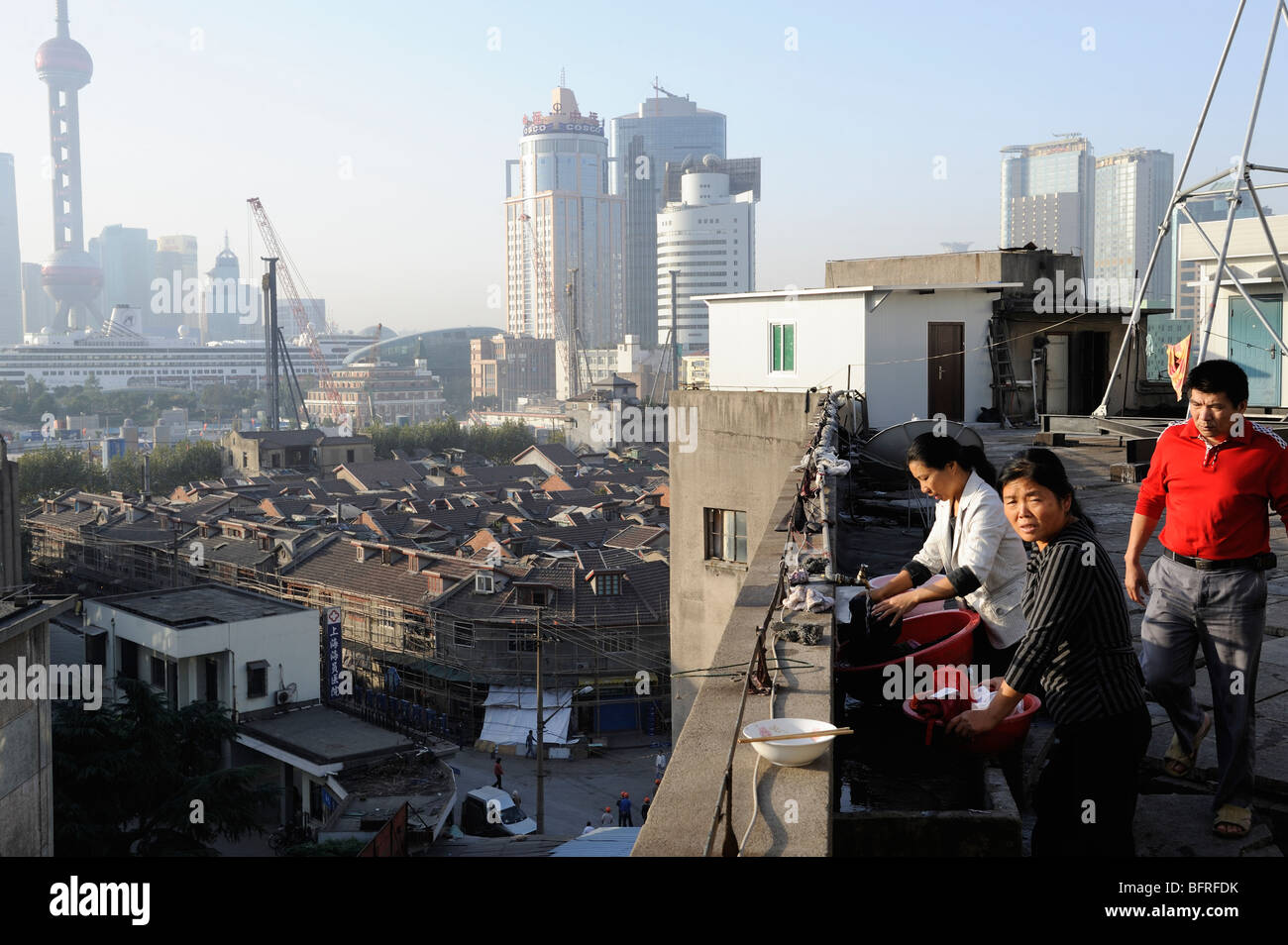 Les femmes migrantes à laver les vêtements en toiture terrasse d'un immeuble à Shanghai, Chine. 21-Oct-2009 Banque D'Images