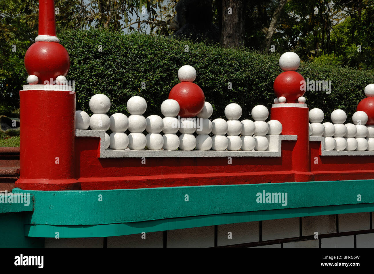 Mur rouge et turquoise insolite ou décoratif avec boules blanches au parc à thème chinois Tiger Balm Gardens, Singapour Banque D'Images