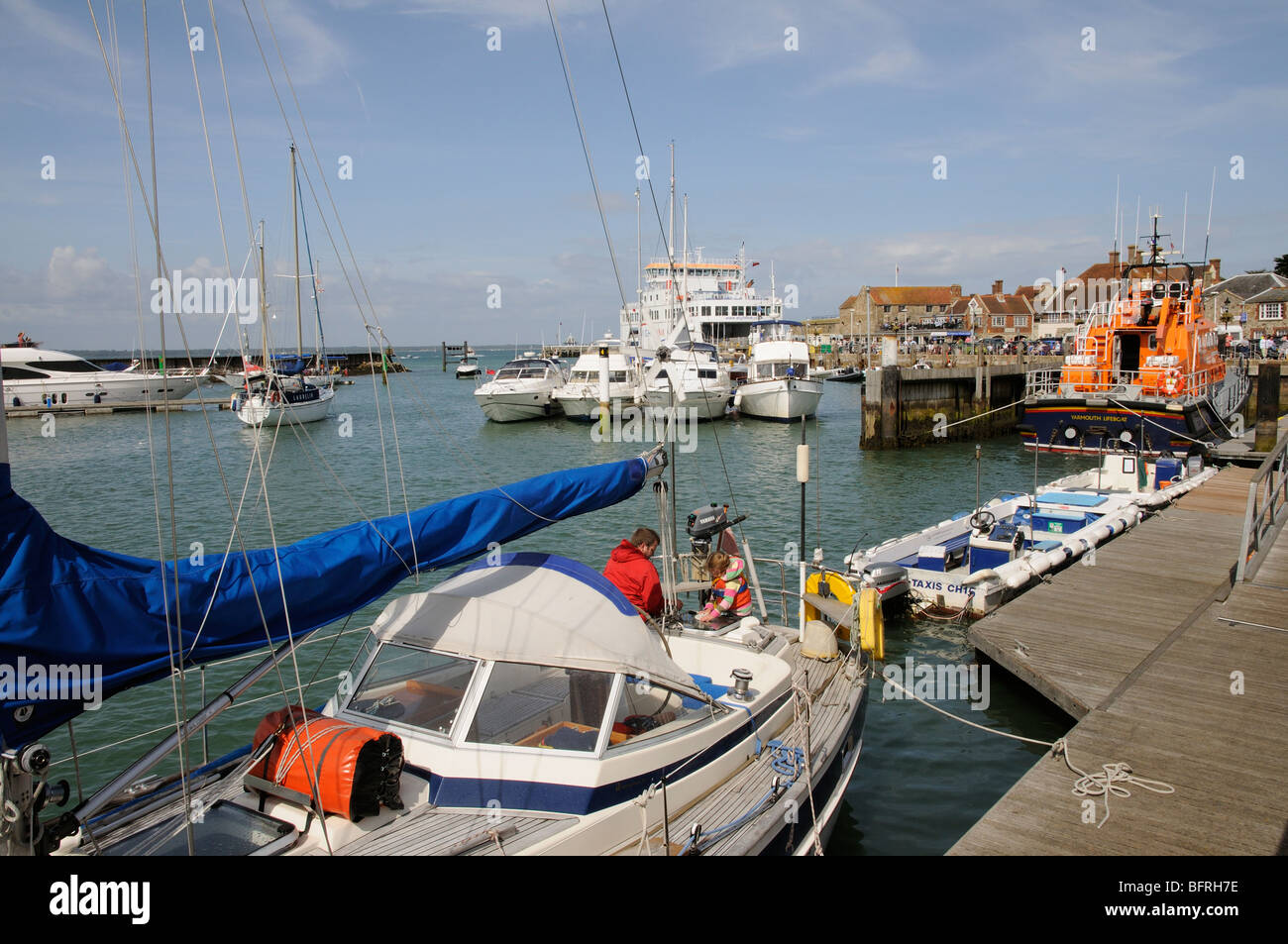 Les bateaux dans le port de Yarmouth Île de Wight dans le sud de l'Angleterre l'homme et enfant de poupe d'un yacht en visite Banque D'Images