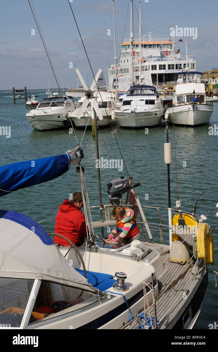 Les bateaux dans le port de Yarmouth Île de Wight dans le sud de l'Angleterre l'homme et enfant de poupe d'un yacht en visite Banque D'Images