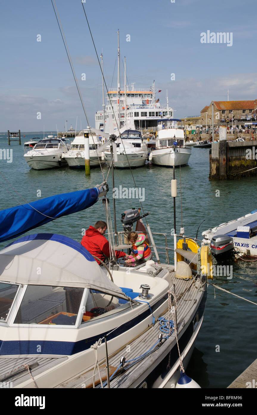 Les bateaux dans le port de Yarmouth Île de Wight dans le sud de l'Angleterre l'homme et enfant de poupe d'un yacht en visite Banque D'Images