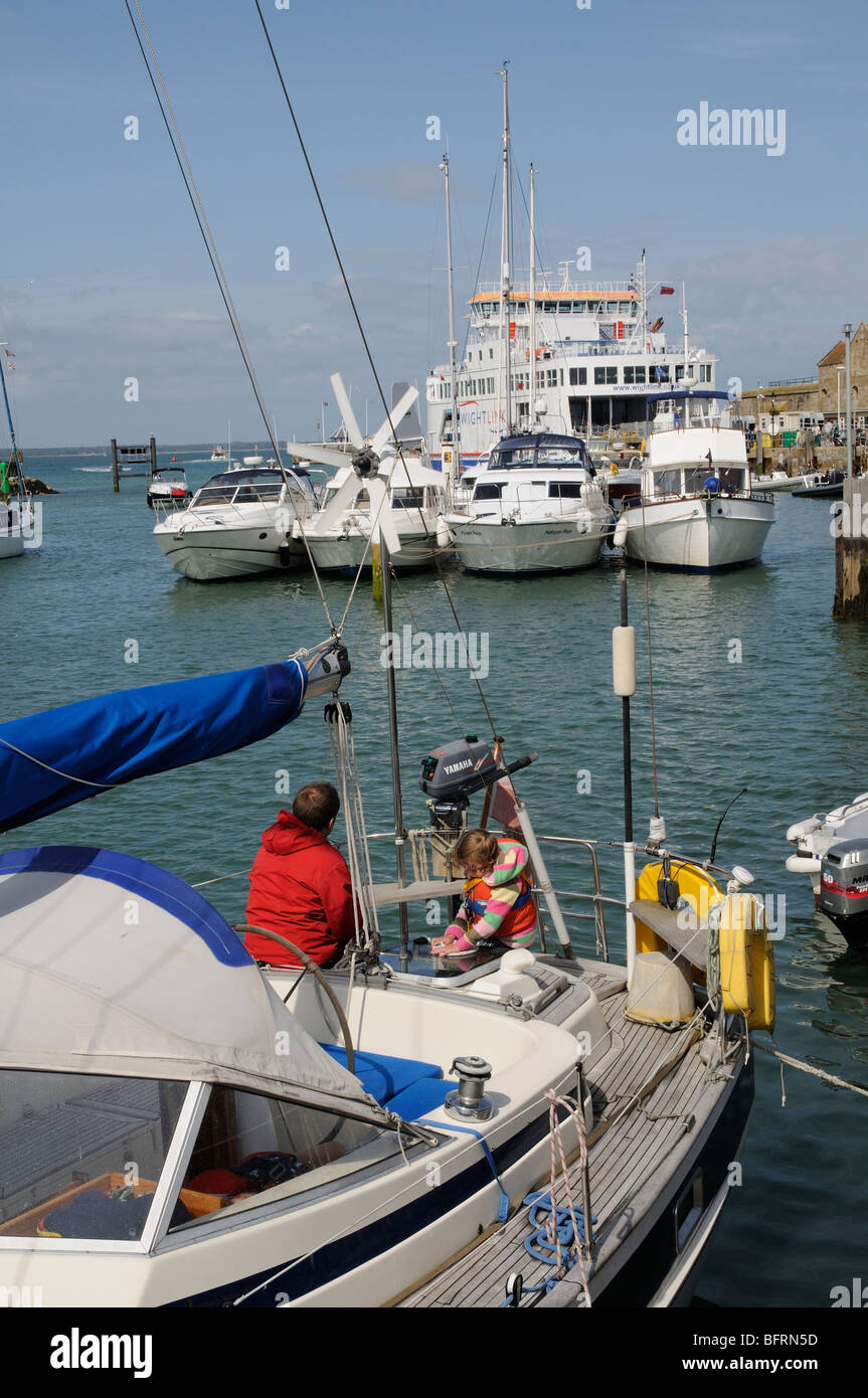 Les bateaux dans le port de Yarmouth Île de Wight dans le sud de l'Angleterre l'homme et enfant de poupe d'un yacht en visite Banque D'Images