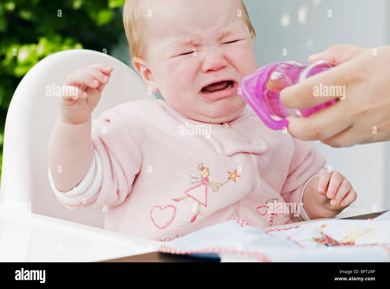 Bébé qui pleure dans une chaise haute Banque D'Images