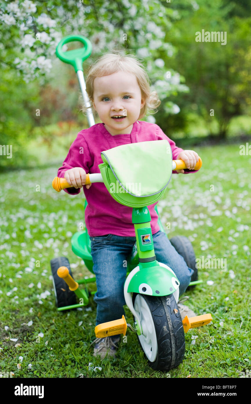 Petite fille équitation de vélo à trois roues Banque D'Images