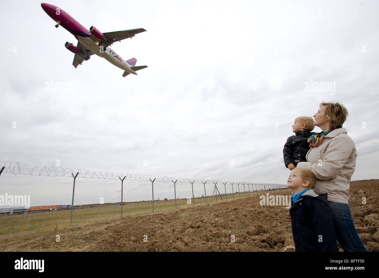 Mère avec enfant de regarder l'avion à l'atterrissage Banque D'Images