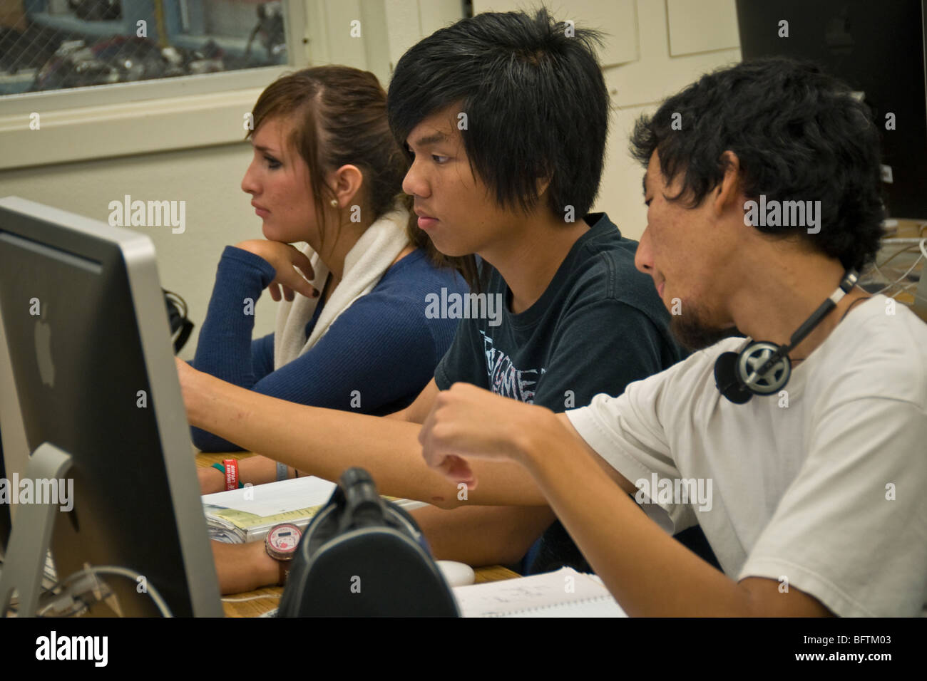 Les élèves du secondaire travaillent sur les ordinateurs Mac en photographie numérique lab. Banque D'Images
