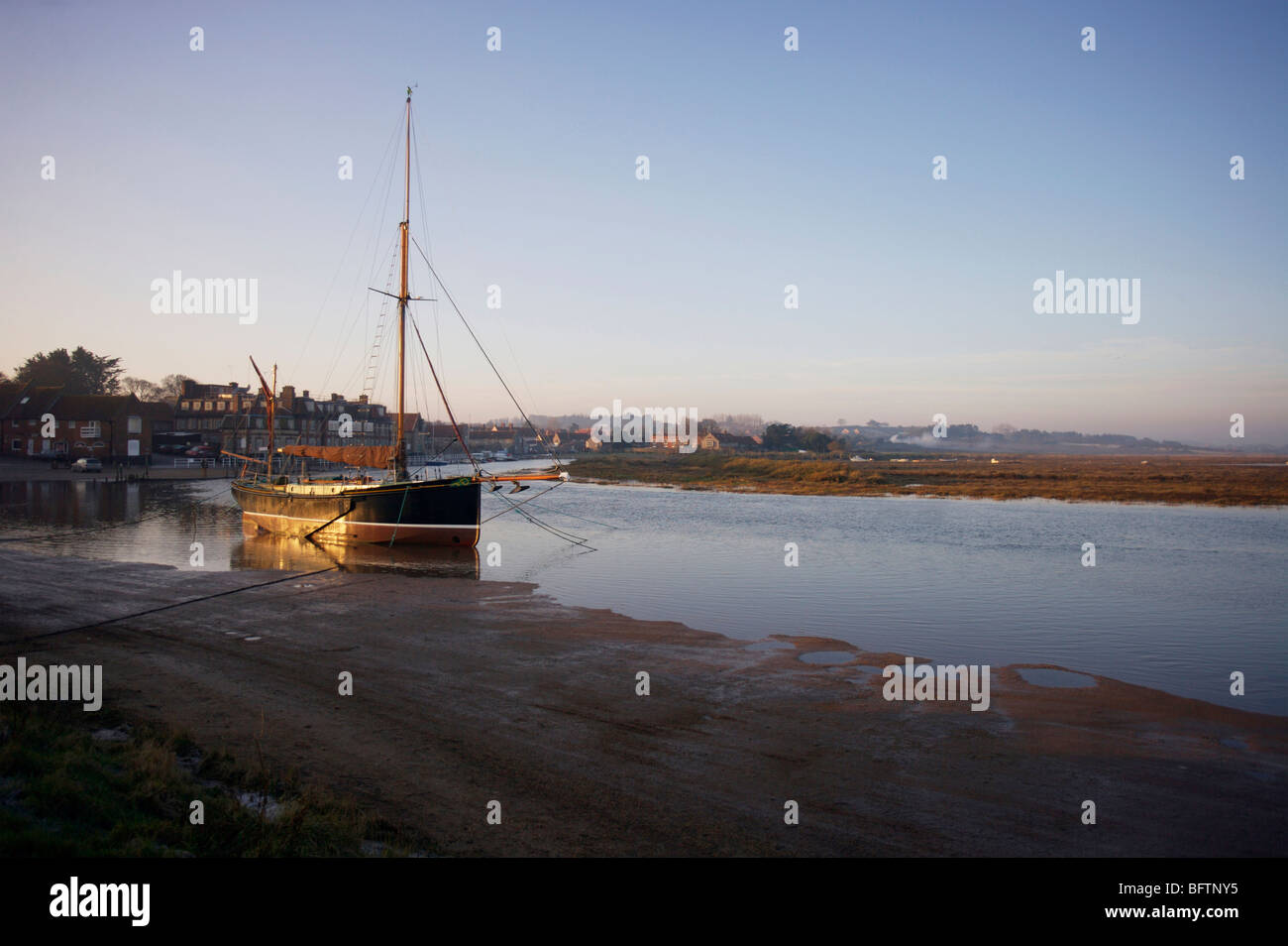 Lever du soleil à Blakeney, avec 'Norfolk' Juno une réplique Thames Barge sur son amarre Banque D'Images