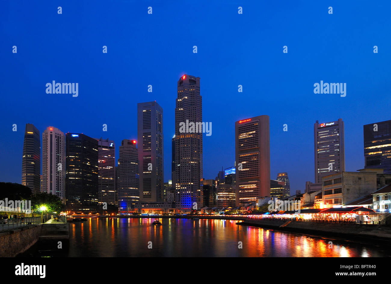 Paysage urbain, paysage urbain ou Skyline de gratte-ciel sur Boat Quay, ou le quartier financier le long de la rivière Singapour, éclairé la nuit, Singapour Banque D'Images