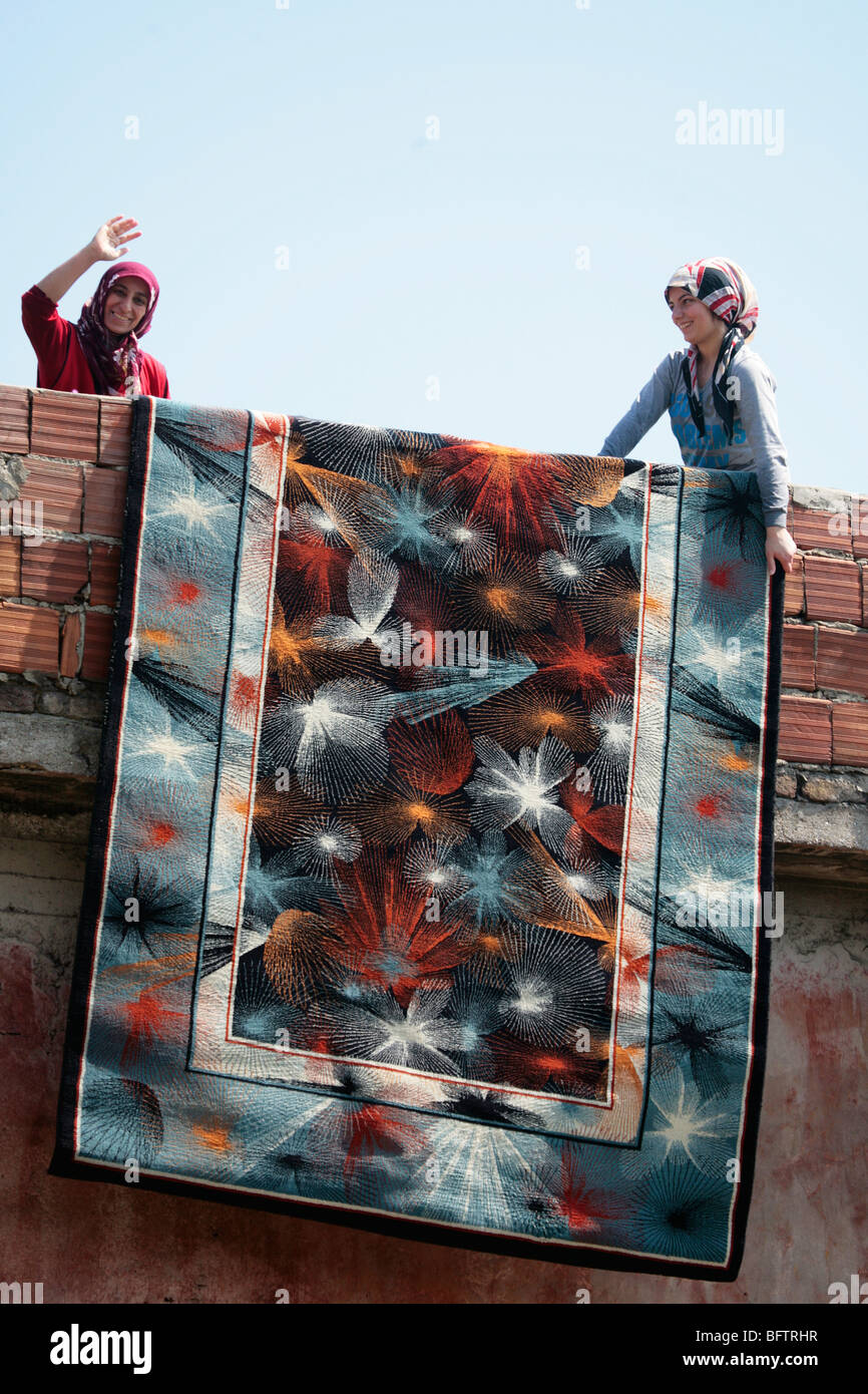 La pendaison des femmes un tapis à sécher à Istanbul, dans le quartier de Fatih musulman traditionnel Banque D'Images